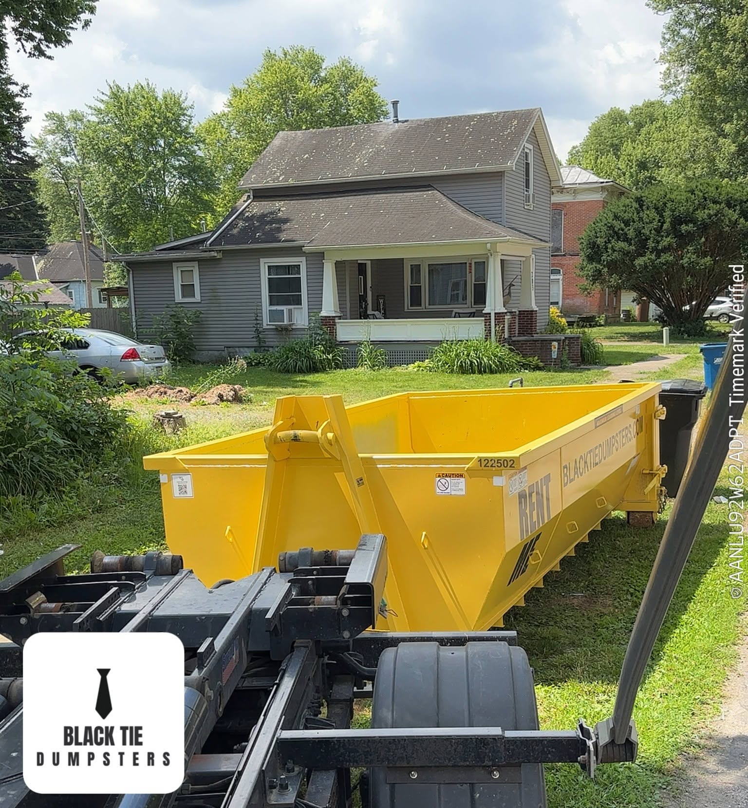12 yard Black Tie Dumpsters roll-off dumpster placed in a residential driveway